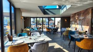 ein Restaurant mit Tischen, Stühlen und Fenstern in der Unterkunft Black Rabbit Croston Boutique Hotel & Restaurant in Croston