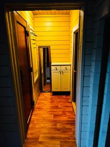 a hallway of a house with yellow walls and wooden floors at River Kemping in Jūrmala +5 photos
