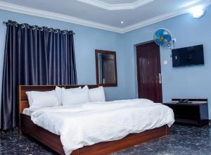 a bedroom with a large bed with a blue wall at Luxury Deluxe 1 Bed, 1 Bath in Otta