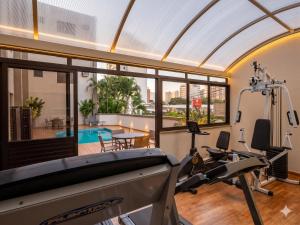 ein Raum mit einem Fitnessraum mit Laufband und Schwimmbad in der Unterkunft Hotel Riviera in Sao Jose do Rio Preto