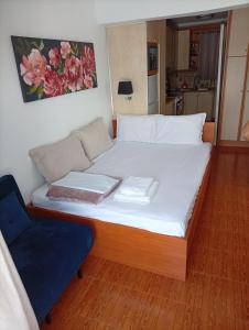 a bed in a room with a blue chair at Demetrius's Penthouse in Chalkida