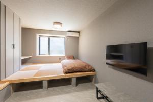 a room with a bed and a flat screen tv at HOTEL PG3 - Vacation STAY 46442v in Habu