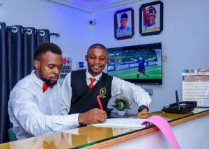 two men sitting at a table signing a paper at Luxury Deluxe 1 Bed, 1 Bath in Otta