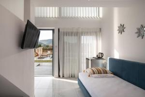 a living room with a bed and a television at Mini Boutique Dragani in Sykia Chalkidikis