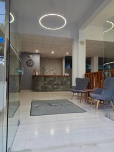 Eine Lobby mit Stühlen und einem Teppich auf dem Boden. in der Unterkunft Avra Beach Hotel in Nydri