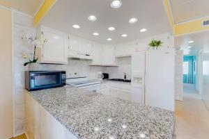 a kitchen with white cabinets and a counter top at Oceanblock on One Twenty-Four in Ocean City