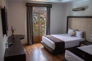a hotel room with a bed and a window at Hotel Paseo de la Presa in Guanajuato
