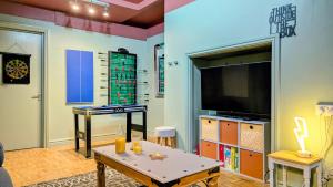 a living room with a flat screen tv and a table at Family Home in Tywyn - Game and Cinema Rooms in Tywyn