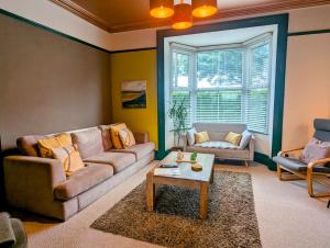 a living room with a couch and a table at Family Home in Tywyn - Game and Cinema Rooms in Tywyn