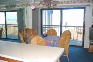 a dining room with a table and chairs and a balcony at Bay Princess 103 in Ocean City