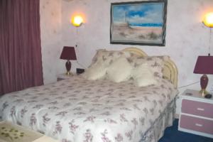 a bedroom with a bed with two lamps and two tables at Bay Princess 103 in Ocean City +2 photos