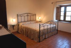 1 dormitorio con 1 cama en una habitación con ventana en Agriturismo Sovanella, en Sovana