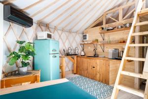 eine Küche mit blauem Kühlschrank und Holzschränken in der Unterkunft Aloha Glamp - Całoroczny glamping nad rzeką z prywatną balią - Stok narciarski, góry, lasy, sauna in Zagórnik