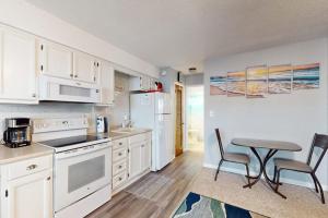 a kitchen with white cabinets and a table with chairs at Sea Nymph in Ocean City +24 photos