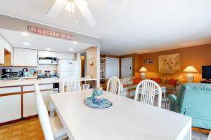 a kitchen and living room with a white table and chairs at Thunder Island 28A in Ocean City
