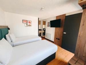a hotel room with a bed and a tv at The Crossway Hotel, Coventry Walsgrave, Part of AG Collection in Coventry