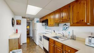a kitchen with wooden cabinets and a sink at White Marlin 105B in Ocean City