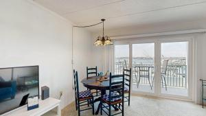 a dining room with a table and chairs and a balcony at White Marlin 105B in Ocean City