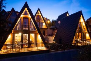 a house with triangular roofs with lights at Zlatarski čardaci in Nova Varoš +11 photos