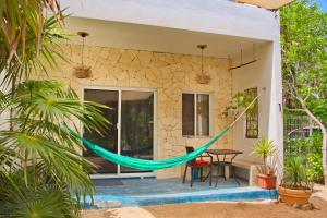 a hammock on the porch of a house at Casa Foto Estudios in El Cuyo