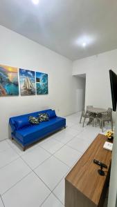 a living room with a blue couch and a table at Casa Sol Nascente in Aquiraz