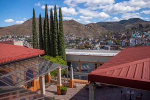 a building with two tall trees and a city at Hotel Paseo de la Presa in Guanajuato