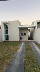 a large white building with a pathway in front of it at Casa Sol Nascente in Aquiraz