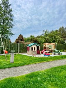 a playground with three play equipment in a yard at Sodyba prie jūros in Palanga
