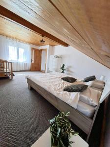 a large bed in a room with a wooden ceiling at Casa Noastra in Drajna de Sus