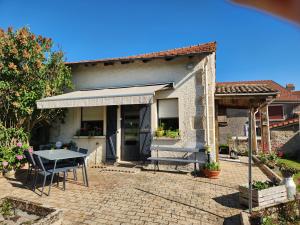 a patio with a table and a house at Les Souchottes, charmante maisonnette in Bulligny