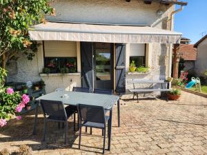 a table and chairs in front of a house at Les Souchottes, charmante maisonnette in Bulligny