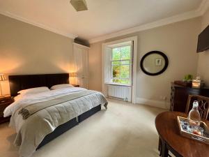 a bedroom with a bed and a table and a window at Blackhill Woods Retreat in Abbeyleix