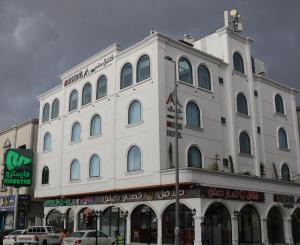 a large white building on the corner of a street at فندق منسي Monsi Hotel in Taif