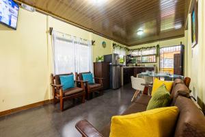 a living room with a couch and chairs and a table at Hormiga's Houses La Fortuna in Fortuna