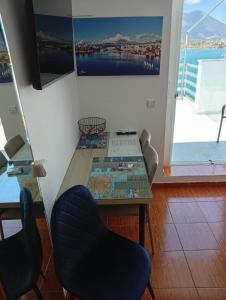 a dining room table with two chairs and a window at Demetrius's Penthouse in Chalkida