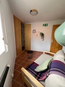 a small room with a bed and a lamp at La Casita de Sara in Cercedilla