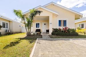 a house with a palm tree in front of it at Hamilton @ Oceanpointe a serene 2bed 2 bath Villa in Lucea