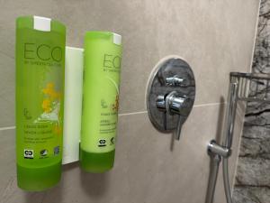 two green shampoo bottles on a wall next to a faucet at Szum Rzeki - Noclegi nad Brdą - Bory Tucholskie in Nadolna Karczma +74 photos