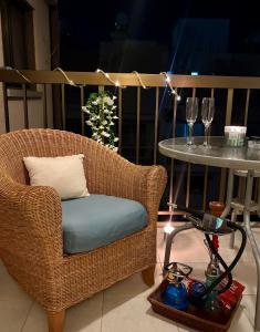 a wicker chair and a table with wine glasses at Kapparis Beach Escape, near beach, BBQ, free parking in Paralimni
