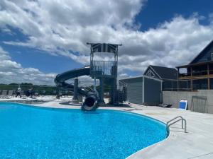 a large swimming pool with a water slide at Branson 10 Bedroom Lakeside Lodge! PRIVATE HEATED POOL! in Hollister