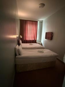 a bedroom with a bed with a red window at The Town Hotel in Bridgwater