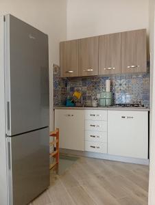 a kitchen with white cabinets and a stainless steel refrigerator at Il borgo in Vico Equense
