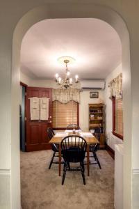 una sala da pranzo con tavolo, sedie e lampadario pendente di Apple Bin Inn a Willow Street