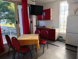 a kitchen with a table and chairs and a refrigerator at Te Shkodrant in Baks-Rrjoll