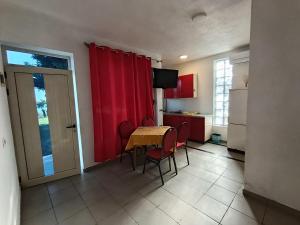 a kitchen with a table and chairs and a red curtain at Te Shkodrant in Baks-Rrjoll +13 photos