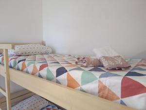 a bed with a colorful comforter and pillows on it at Te Shkodrant in Baks-Rrjoll