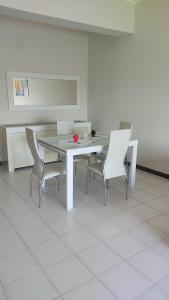 a dining room with a white table and chairs at Brezza dello Stretto in Mili Marina +11 photos
