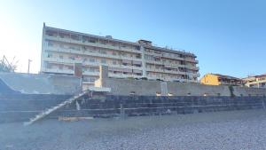 a building in the background with stairs and a building at Brezza dello Stretto in Mili Marina