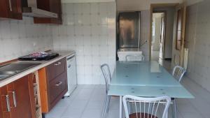 a kitchen with a table and chairs and a refrigerator at Brezza dello Stretto in Mili Marina