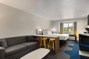 a hotel room with a bed and a couch at Microtel Inn & Suites by Wyndham Culpeper in Culpeper